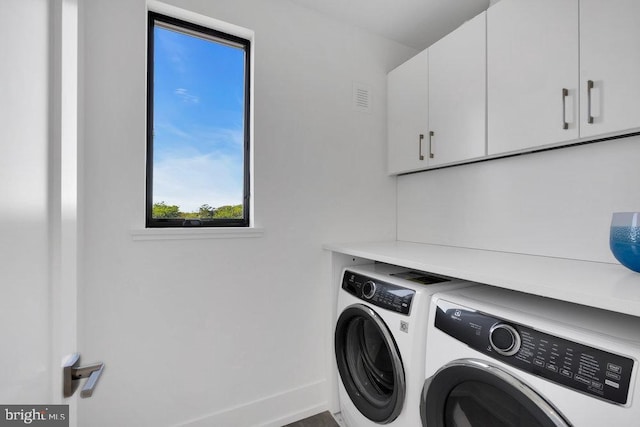 washroom with independent washer and dryer and cabinets