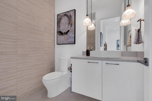 bathroom with vanity, tile patterned floors, tile walls, and toilet