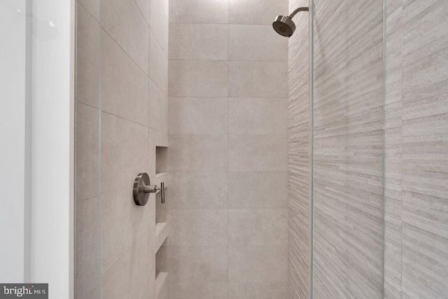 interior details featuring a tile shower