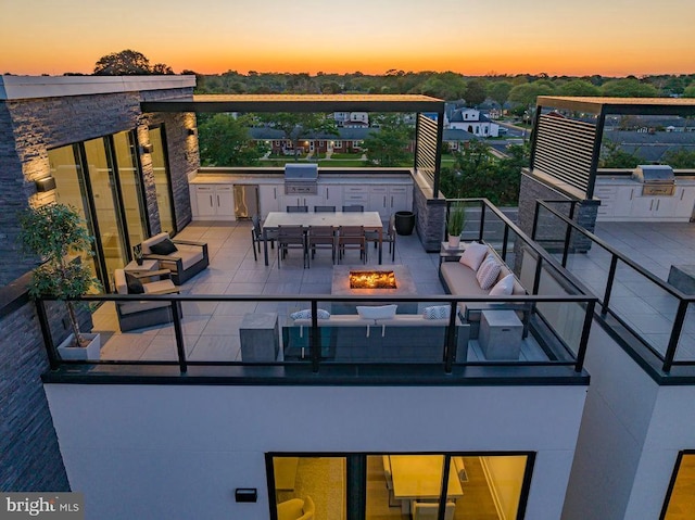 exterior space with area for grilling, a grill, an outdoor bar, and an outdoor living space with a fire pit