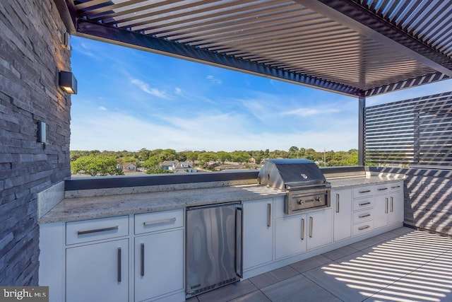 view of patio / terrace with exterior kitchen, area for grilling, and a pergola