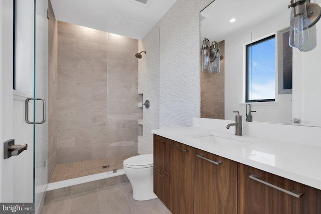 bathroom featuring tile patterned flooring, vanity, walk in shower, and toilet