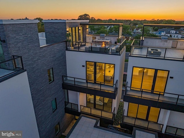 back house at dusk featuring a balcony