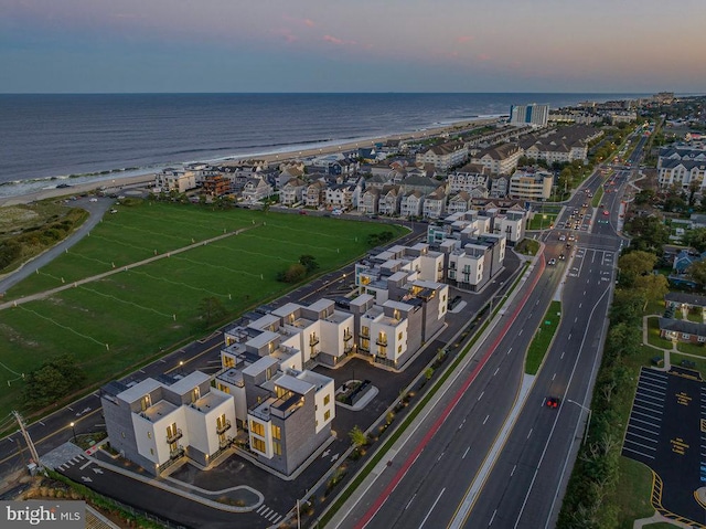 aerial view at dusk featuring a water view