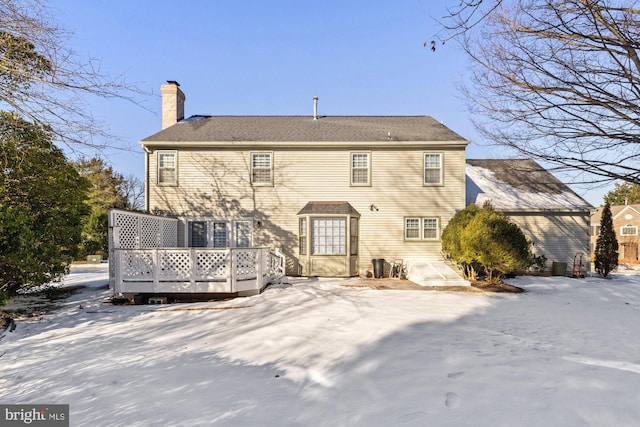 snow covered property with a wooden deck