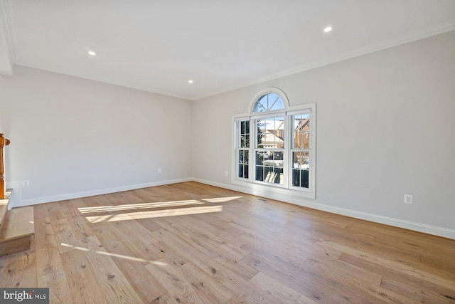 spare room with crown molding and light wood-type flooring