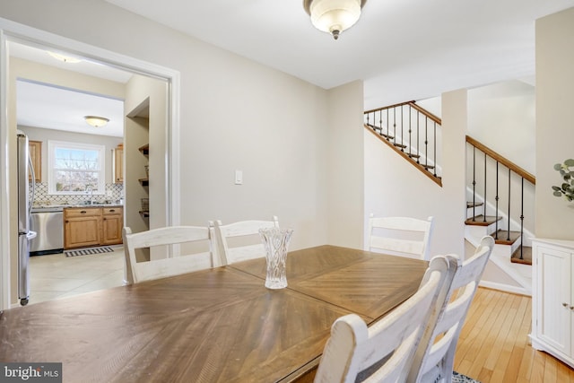 dining room featuring sink and light wood-type flooring