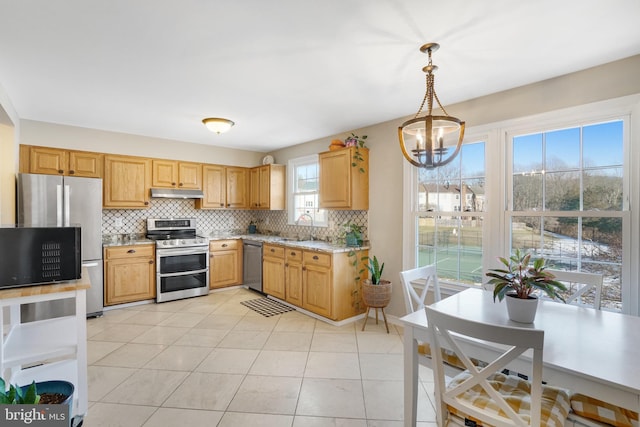 kitchen featuring sink, backsplash, hanging light fixtures, light tile patterned floors, and stainless steel appliances