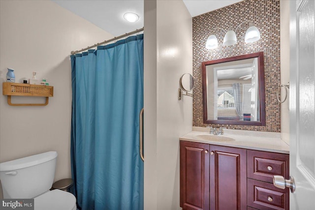 bathroom with tasteful backsplash, toilet, walk in shower, and vanity