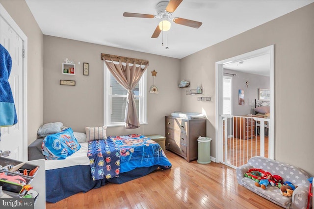 bedroom featuring hardwood / wood-style flooring, multiple windows, and ceiling fan