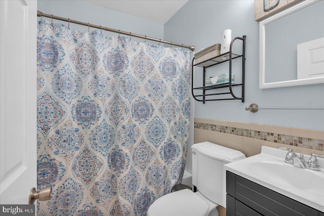 bathroom featuring tile walls, toilet, and vanity