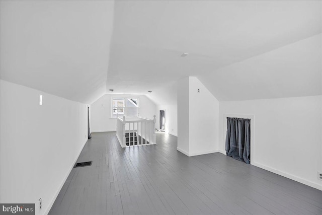 bonus room with dark hardwood / wood-style flooring and lofted ceiling