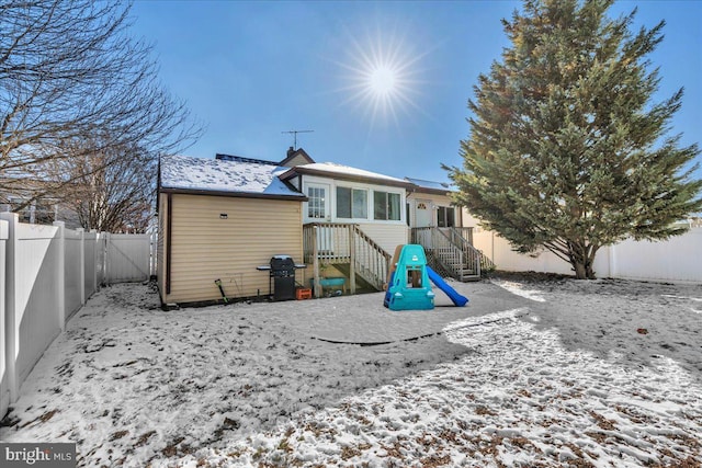 view of snow covered back of property