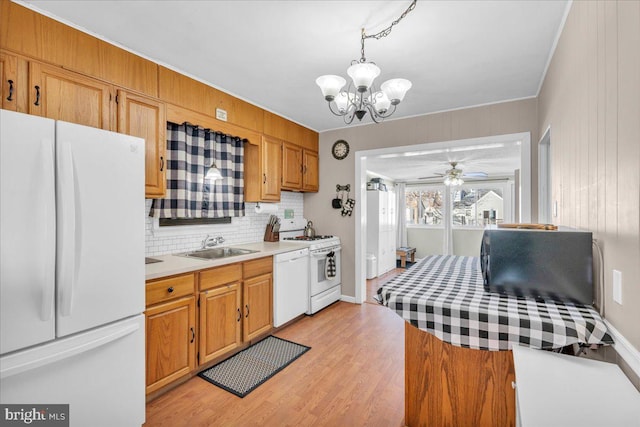 kitchen featuring pendant lighting, white appliances, tasteful backsplash, light hardwood / wood-style floors, and sink