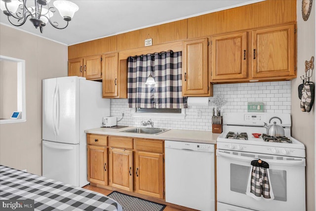 kitchen with sink, backsplash, white appliances, and a notable chandelier