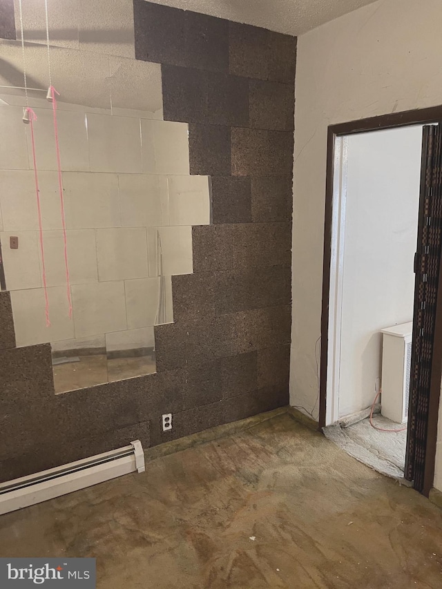 stairs featuring concrete floors and a baseboard heating unit