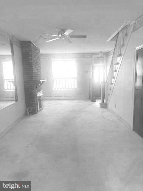 interior space featuring ceiling fan, a healthy amount of sunlight, and a brick fireplace