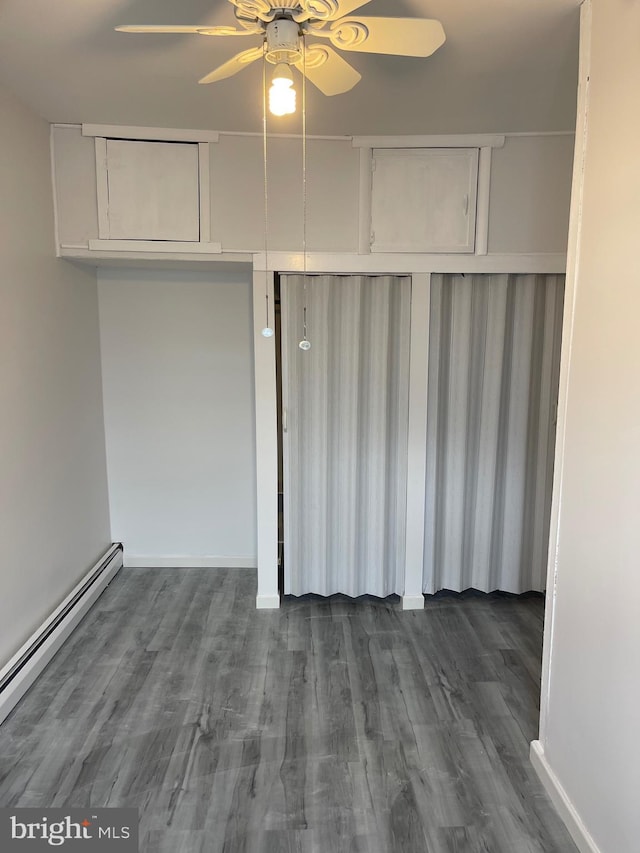 interior space with dark wood finished floors, a closet, ceiling fan, and baseboard heating