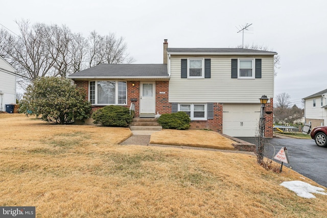 tri-level home with a garage and a front yard