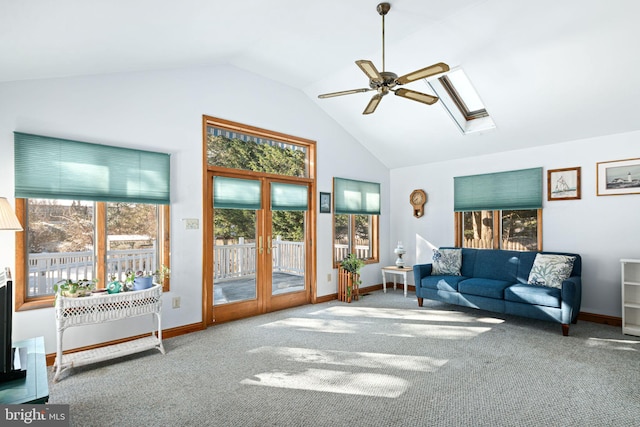 carpeted living room featuring french doors, ceiling fan, plenty of natural light, and lofted ceiling with skylight