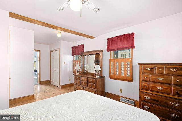 bedroom featuring multiple windows, a closet, ceiling fan, light hardwood / wood-style flooring, and beam ceiling