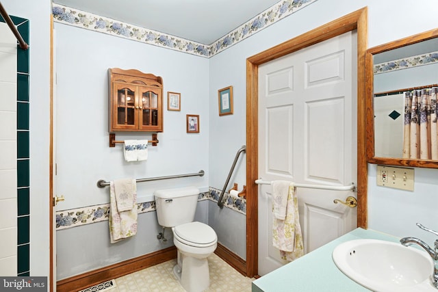 bathroom featuring toilet, vanity, and a shower with curtain