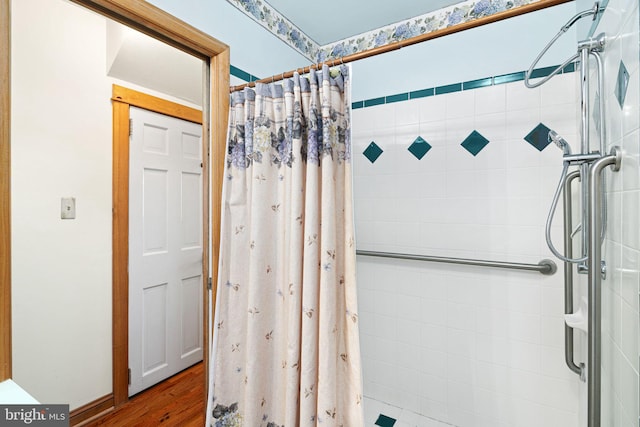 bathroom featuring hardwood / wood-style flooring and walk in shower