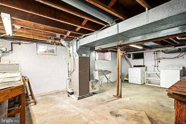 basement featuring heating unit and independent washer and dryer