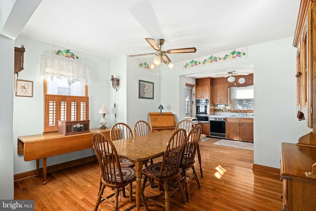 dining area with ceiling fan, sink, and light hardwood / wood-style floors