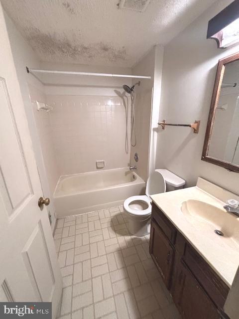 full bathroom featuring tiled shower / bath combo, toilet, a textured ceiling, and vanity