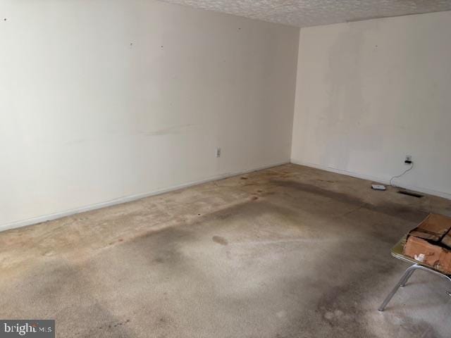 unfurnished room with a textured ceiling