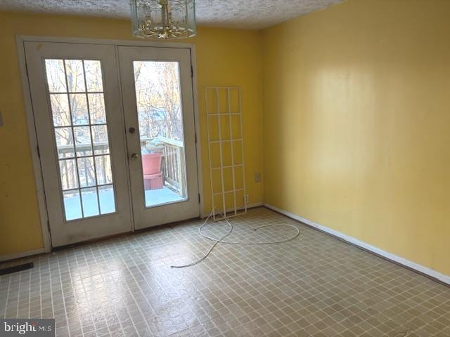 entryway featuring a textured ceiling and french doors