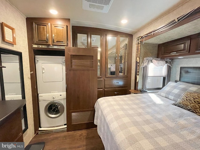 bedroom featuring stacked washer and clothes dryer and lofted ceiling