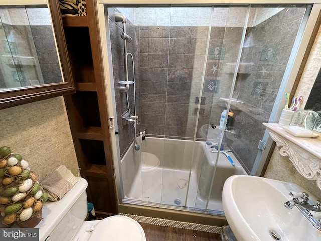 full bathroom featuring toilet, enclosed tub / shower combo, and sink