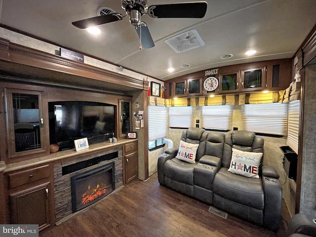 cinema with ceiling fan, dark hardwood / wood-style floors, and crown molding