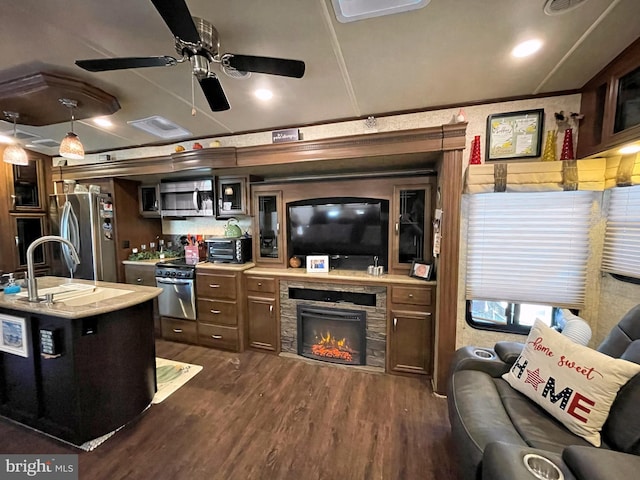 kitchen with stainless steel appliances, dark wood-type flooring, a fireplace, pendant lighting, and a center island