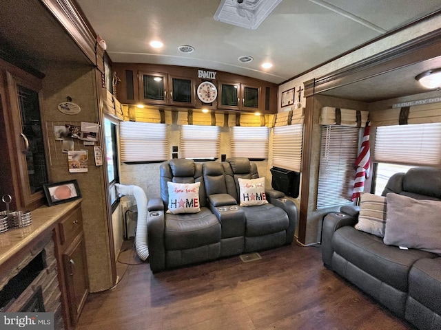 home theater room with lofted ceiling, dark hardwood / wood-style flooring, and crown molding