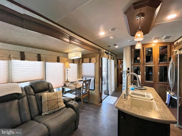 living room with dark wood-type flooring, sink, and ornamental molding