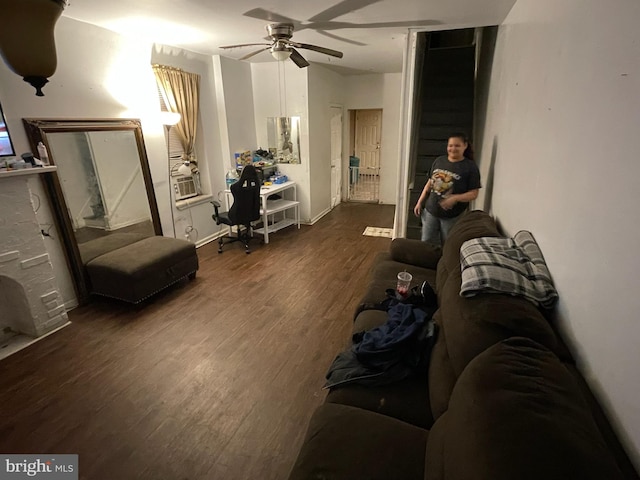 living room featuring ceiling fan and dark wood-type flooring