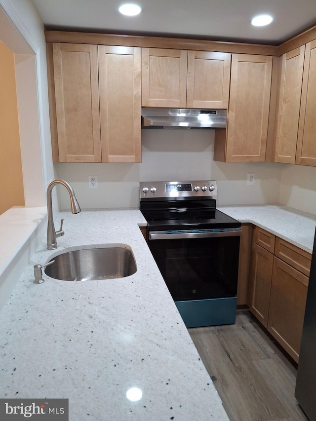 kitchen with light stone counters, sink, stainless steel range with electric cooktop, and light hardwood / wood-style flooring