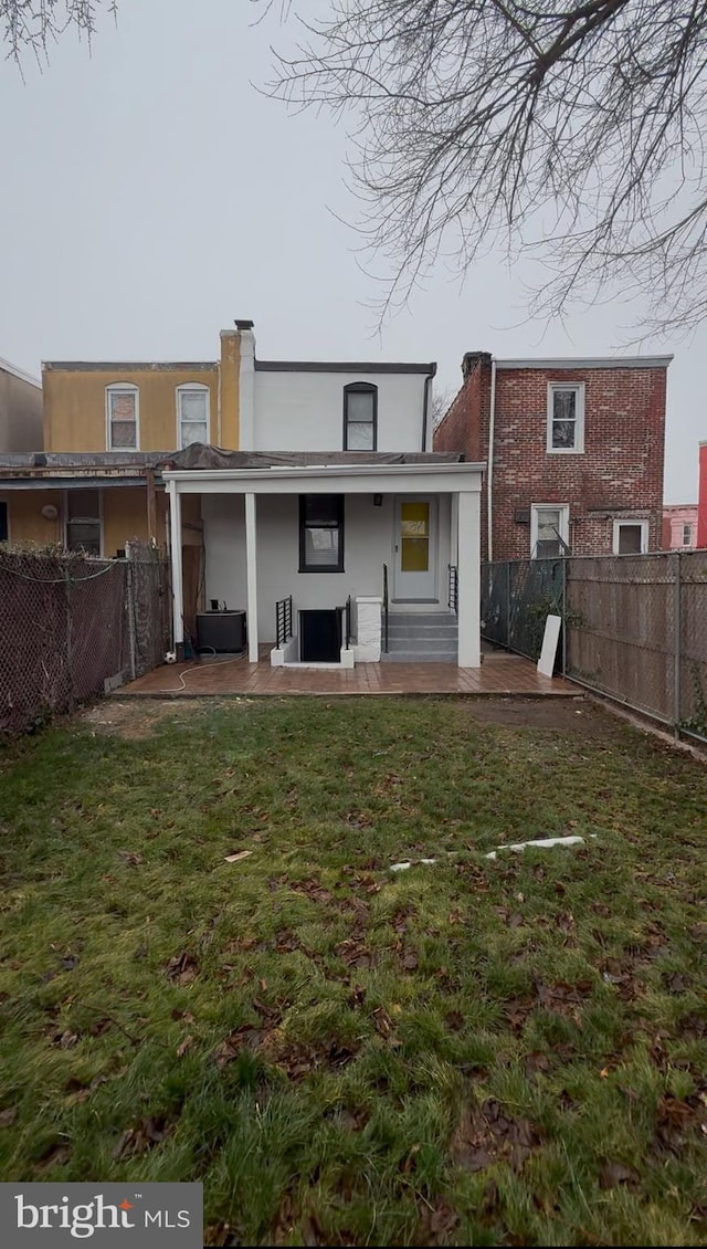 rear view of house with a patio area and a lawn