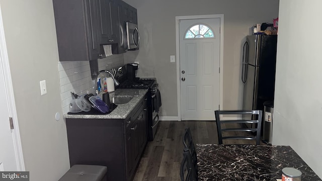 kitchen featuring black appliances, light stone countertops, tasteful backsplash, sink, and dark hardwood / wood-style flooring