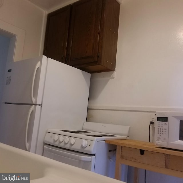 kitchen with white appliances and dark brown cabinetry