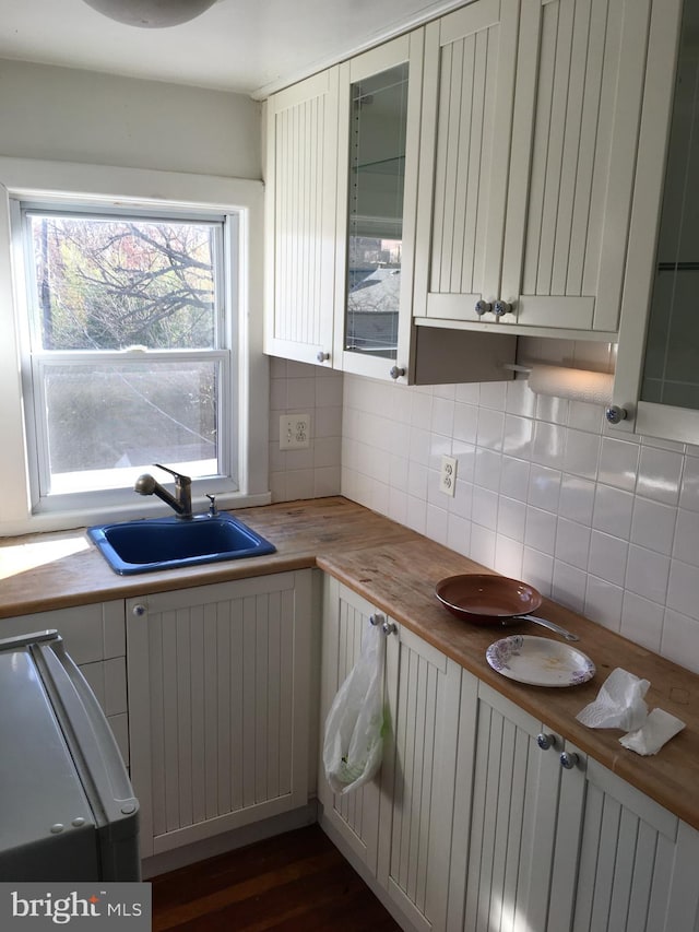 kitchen featuring sink, backsplash, and wood counters