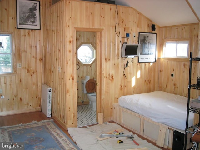 unfurnished bedroom featuring ensuite bathroom and multiple windows