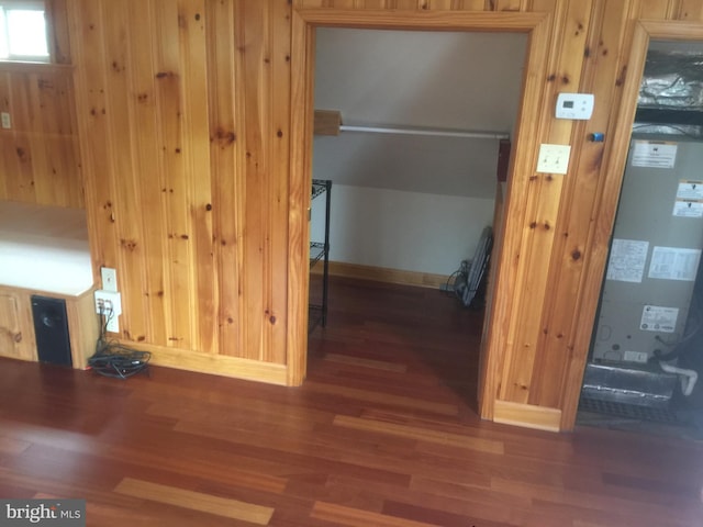 interior space with dark hardwood / wood-style flooring and wood walls