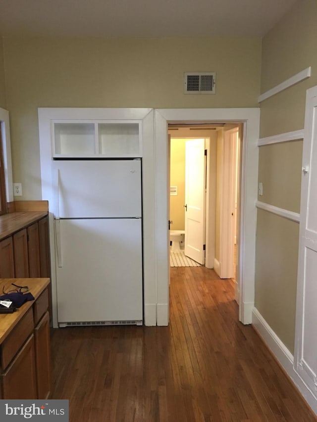 kitchen with dark hardwood / wood-style floors and white refrigerator