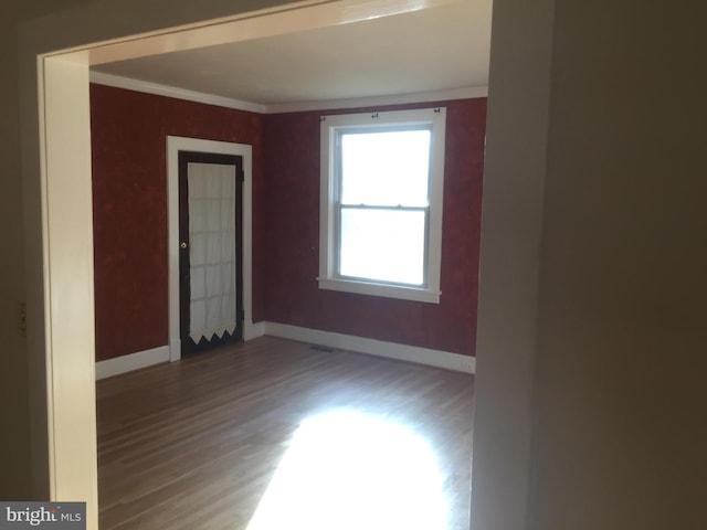 spare room with hardwood / wood-style flooring and crown molding