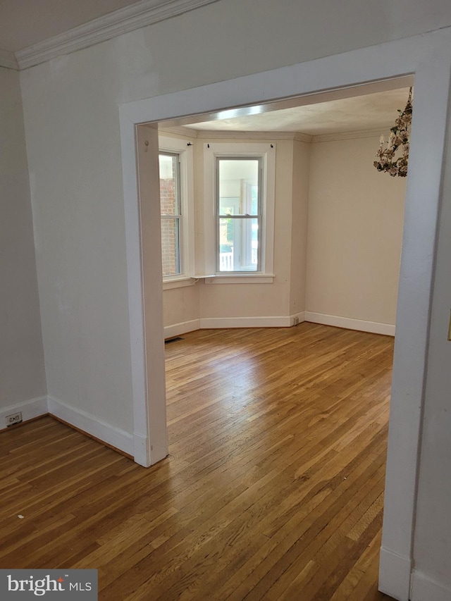 spare room with hardwood / wood-style flooring and ornamental molding