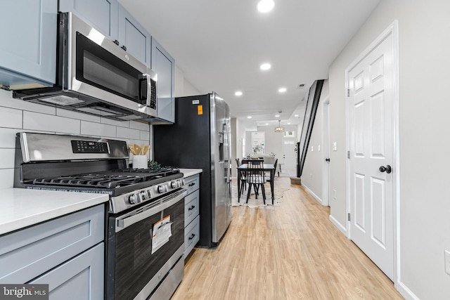 kitchen featuring light hardwood / wood-style flooring, stainless steel appliances, and tasteful backsplash